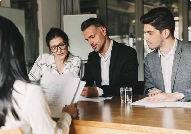 three people sat looking at something on paper
