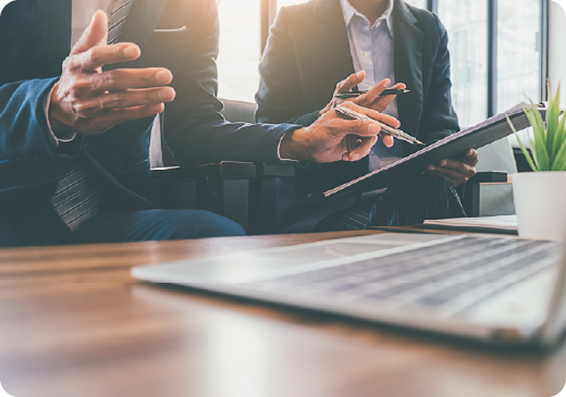 a man explaining something using his hands, looking at a laptop