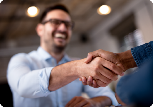 a man smiling at someone else and shaking hands