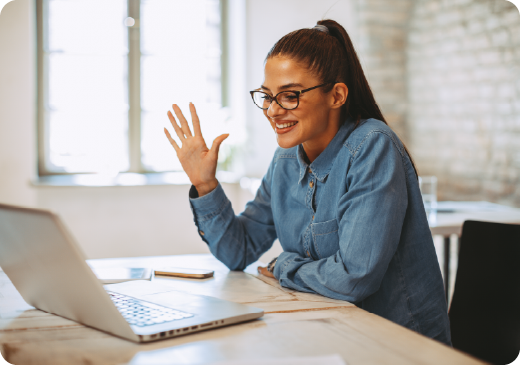 someone waving at a laptop during a video call